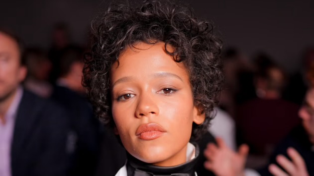 A Whitney Moment: Taylor Russell Stuns In Retro Curly Cut At Dior’s Runway Presentation